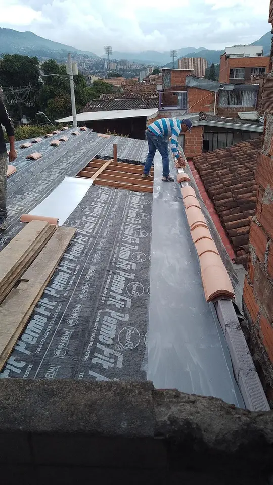 Técnico instalando manto impermeabilizante sobre la nueva estructura de la cubierta