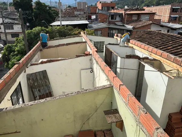 Cuadrilla retirando la cubierta antigua de una casa en Medellín para reconstruirla